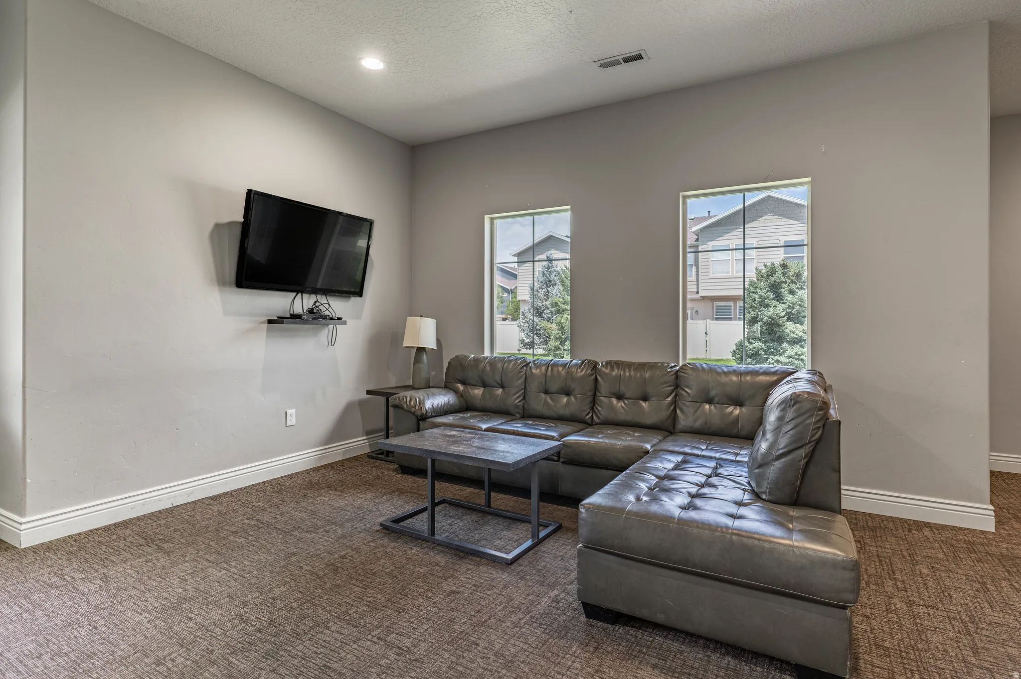 Living area with patterned carpet flooring, recessed lighting, and base molding