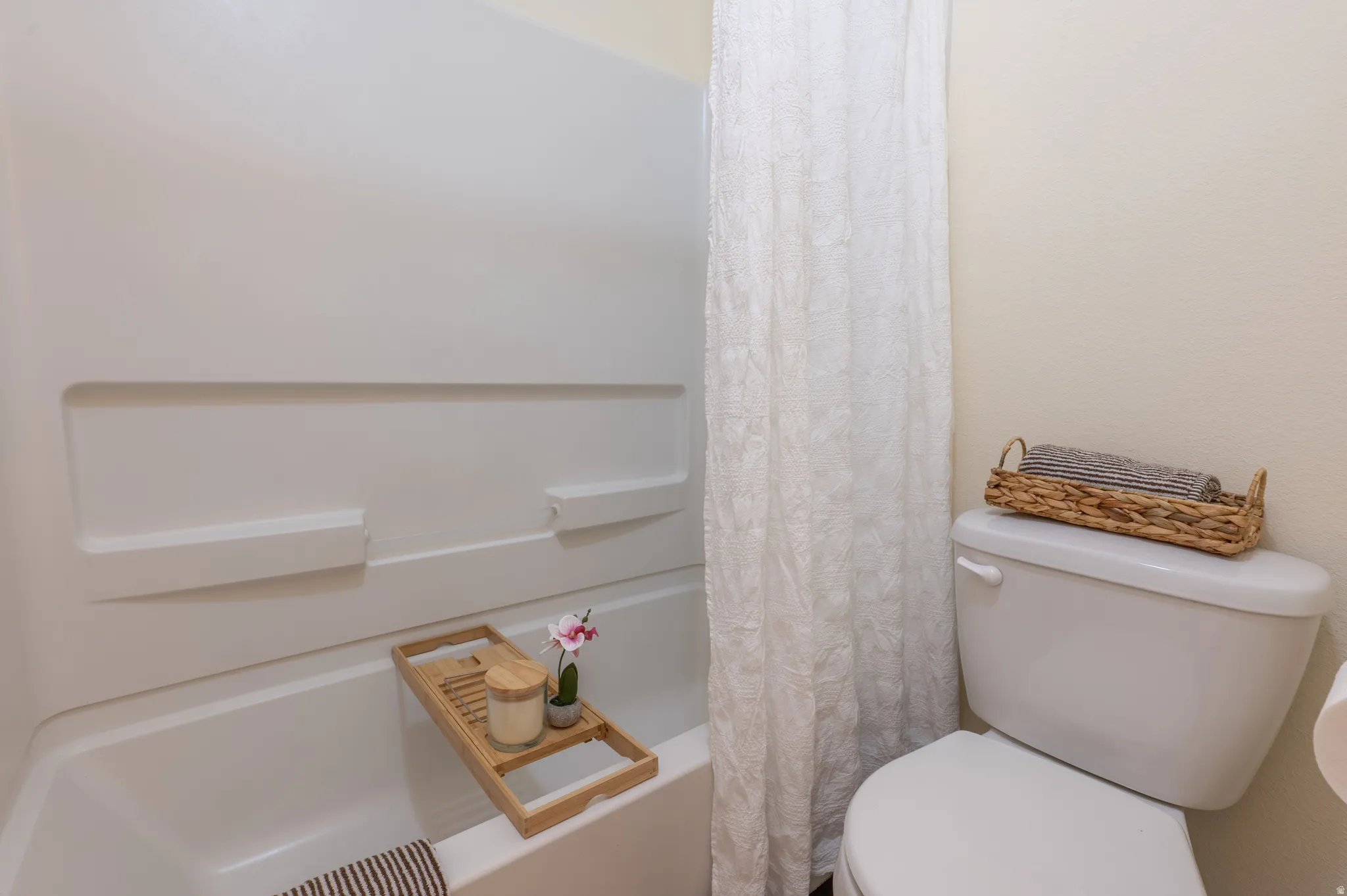 White bathtub and shower combination with integrated shelving