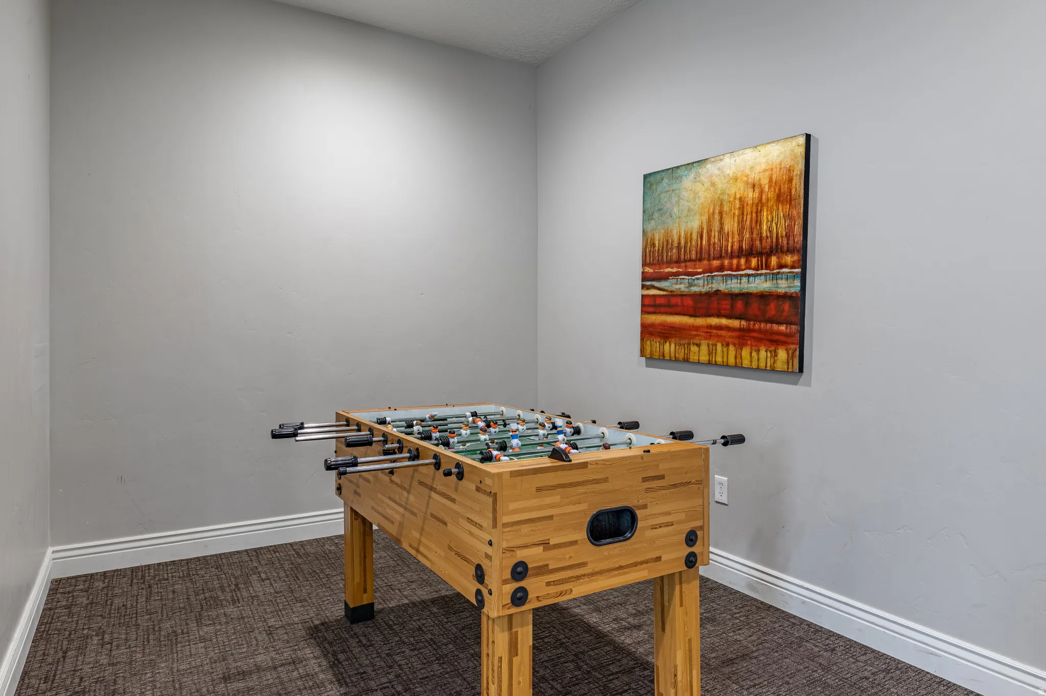 Carpeted room with light gray walls and white baseboards