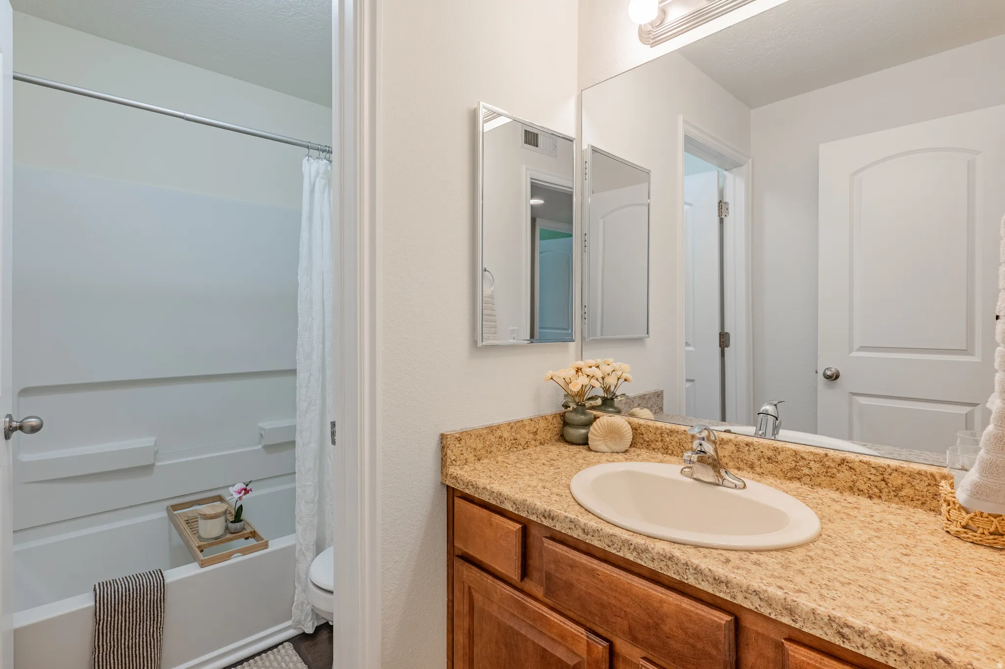 Bathroom featuring a vanity with a light-colored countertop, an integrated sink, and a chrome faucet