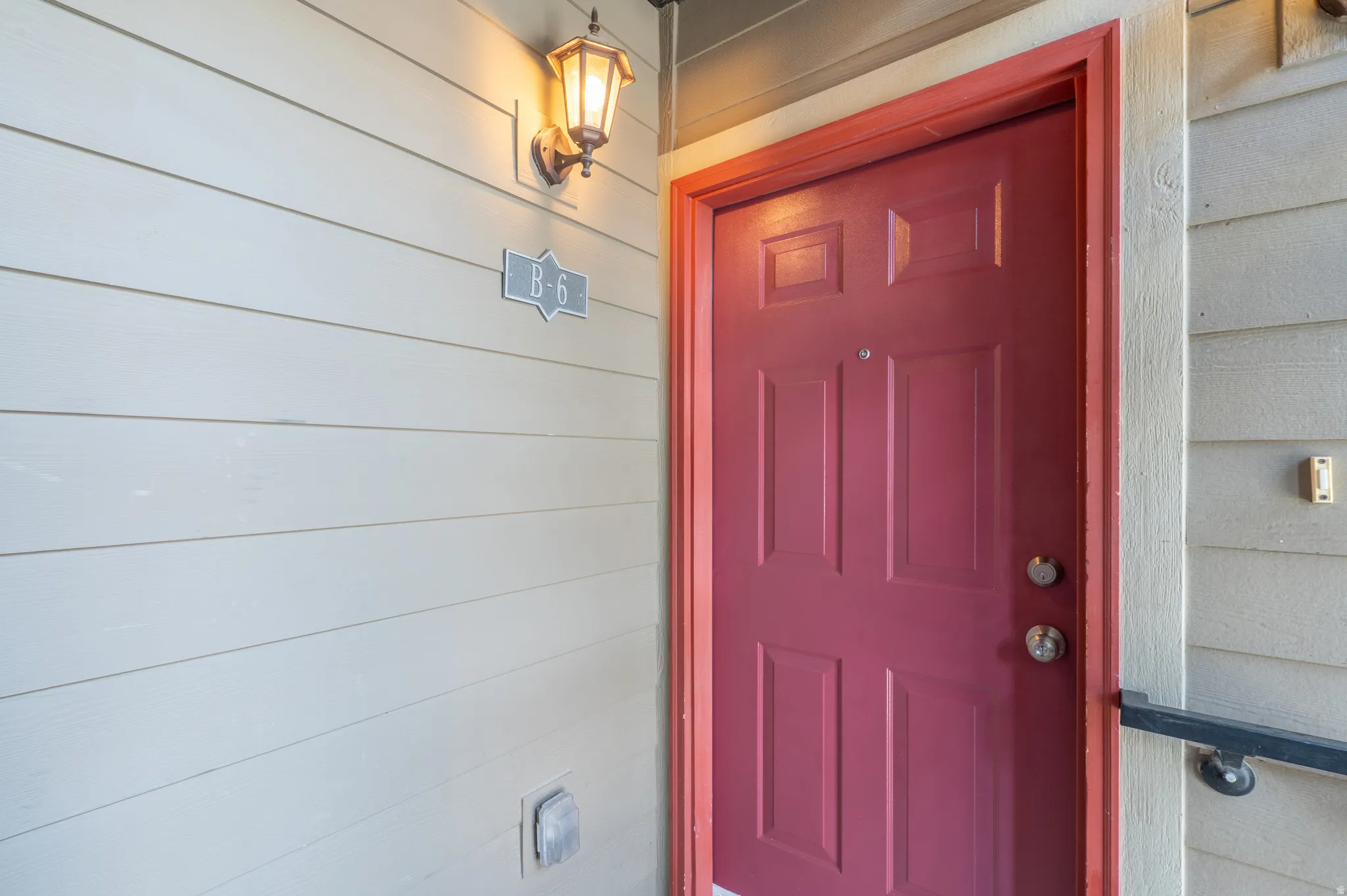 Entry door featuring a vibrant red finish and panel detailing
