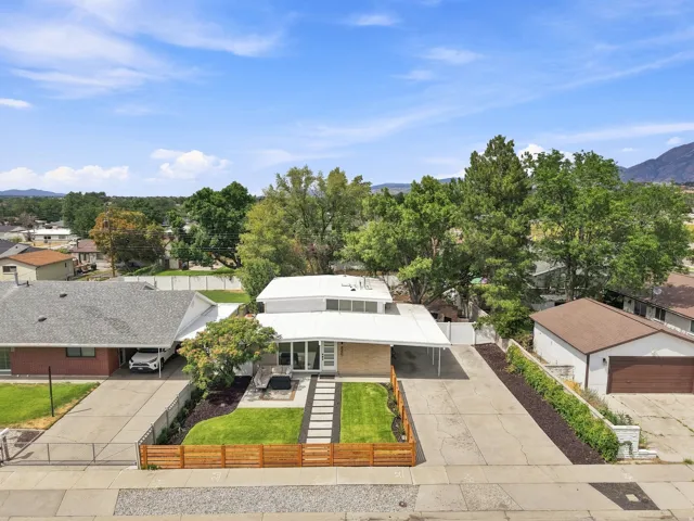 Modern two-story residence featuring a white flat roof and a front-facing carport