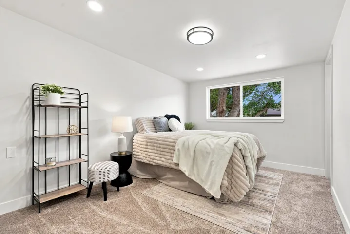 Carpeted room featuring a double-pane window, recessed lighting, and a modern flush-mount ceiling fixture