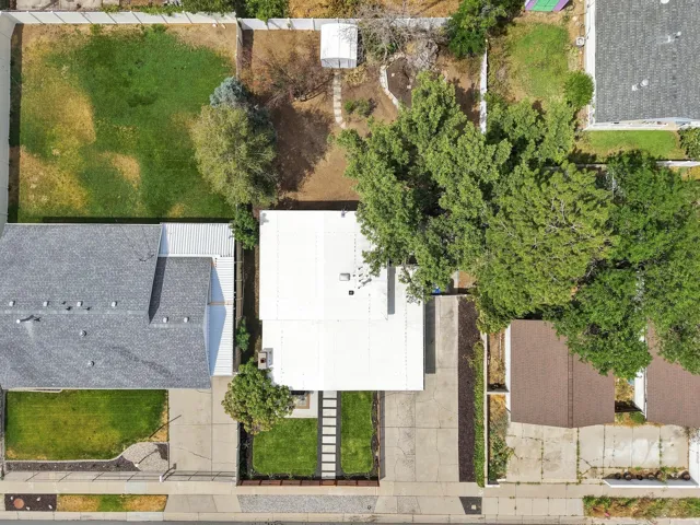 Property featuring a flat roofline and a large, mature tree providing shade