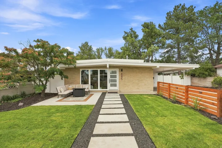 Mid-century modern residence featuring a light brick exterior and a flat roofline