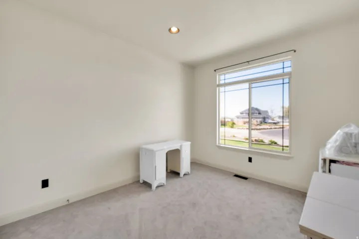 Bright room featuring neutral-toned walls, recessed lighting, and a large window with white trim