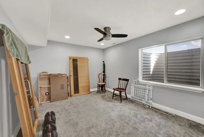 Carpeted room featuring a built-in sauna, recessed lighting, and a ceiling fan