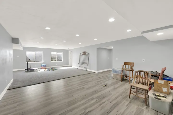 Spacious lower level featuring recessed lighting, a combination of wood-finish flooring and carpet, neutral wall tones, and multiple egress windows