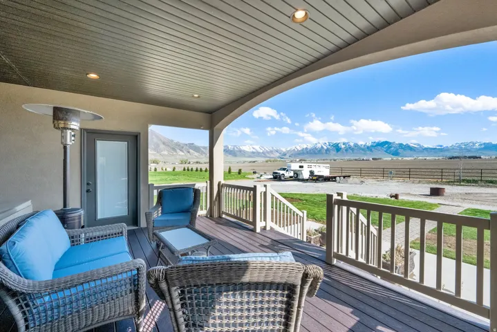 Covered outdoor patio featuring a dark composite deck and light-toned railing