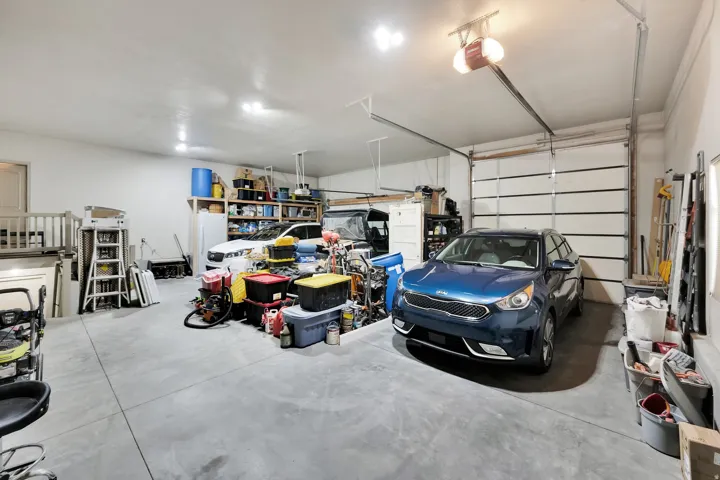 Spacious garage featuring concrete flooring and two overhead garage doors