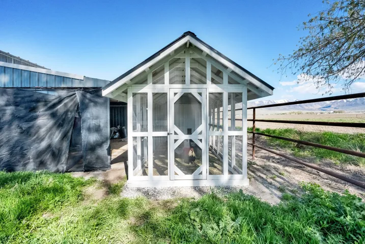 White framed outbuilding with a peaked roof