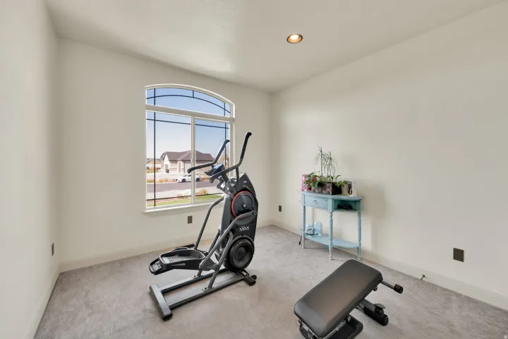 Room featuring a large arched window, light gray carpeting, recessed ceiling lighting, and white wall finishes