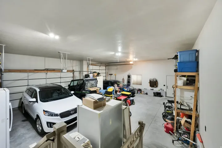 Spacious garage with light grey walls, white ceiling, and concrete flooring
