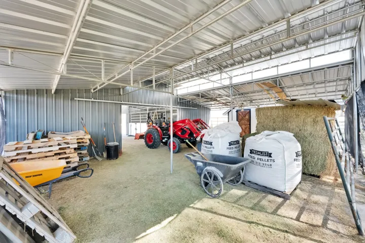 Spacious metal structure featuring a corrugated roof, open-air design, and corrugated metal walls