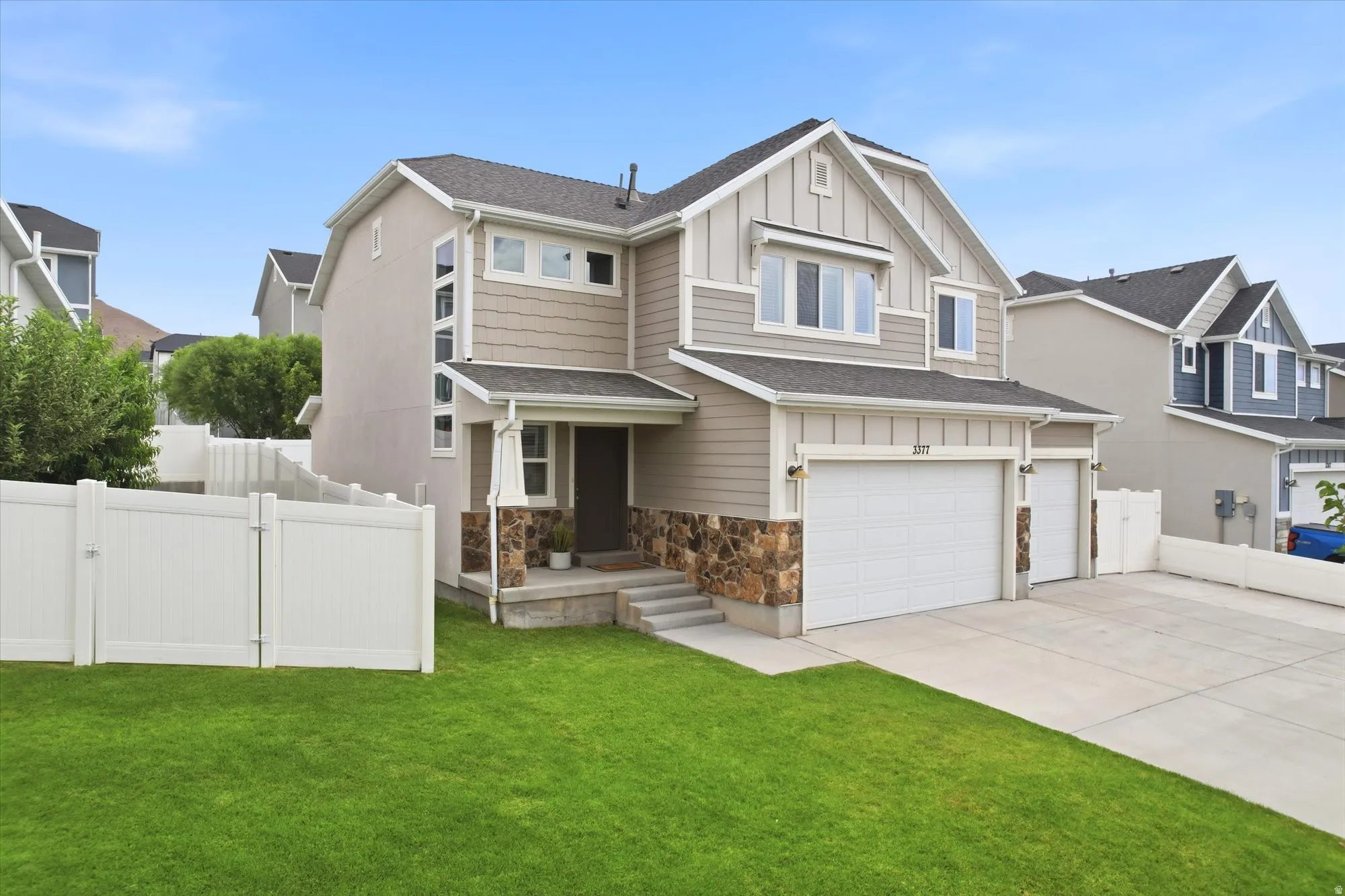 Contemporary two-story residence featuring a multi-textured facade with stone, horizontal siding, and vertical board and batten accents