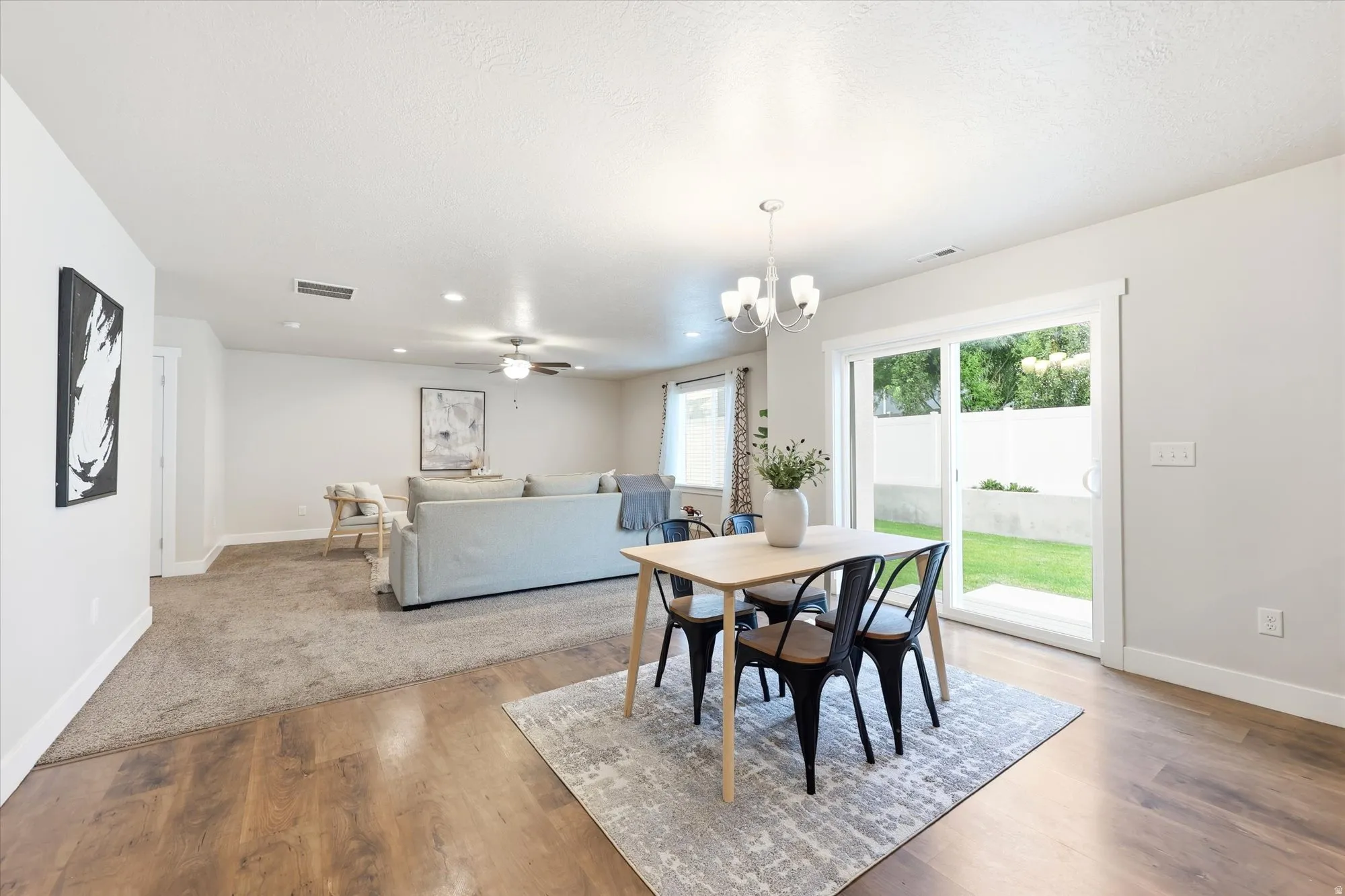 Spacious open-concept living area featuring wood-finish flooring, recessed lighting, and a ceiling fan