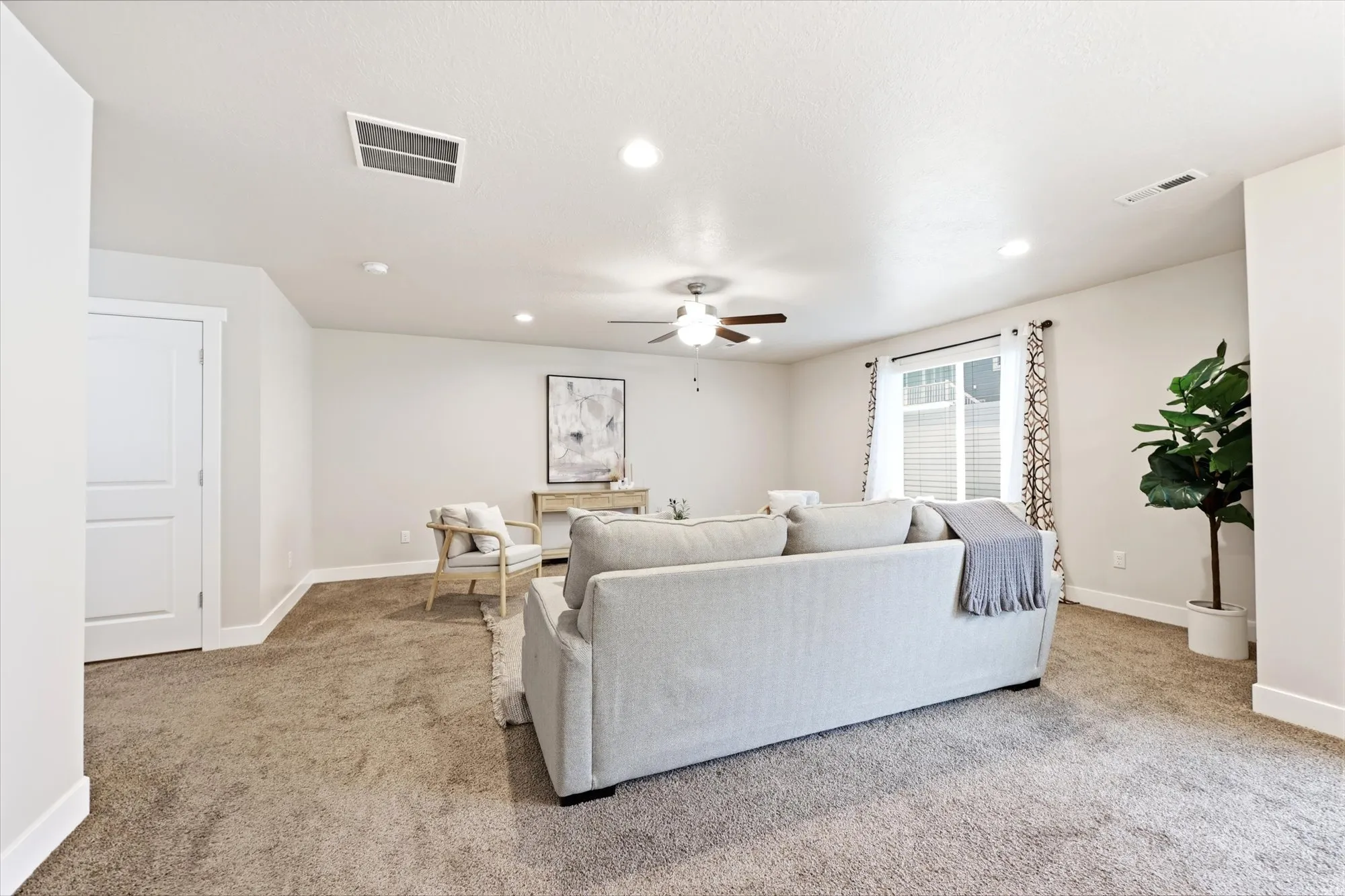Spacious room featuring neutral carpeting, recessed lighting, a ceiling fan, and white baseboards