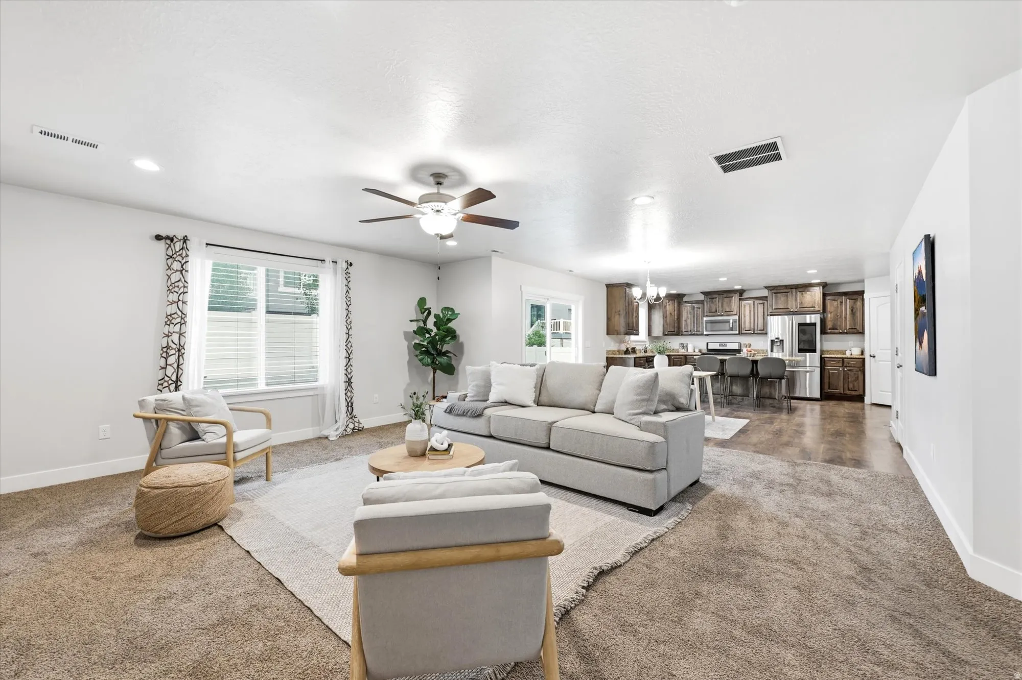 Expansive living area featuring carpeted flooring and recessed lighting