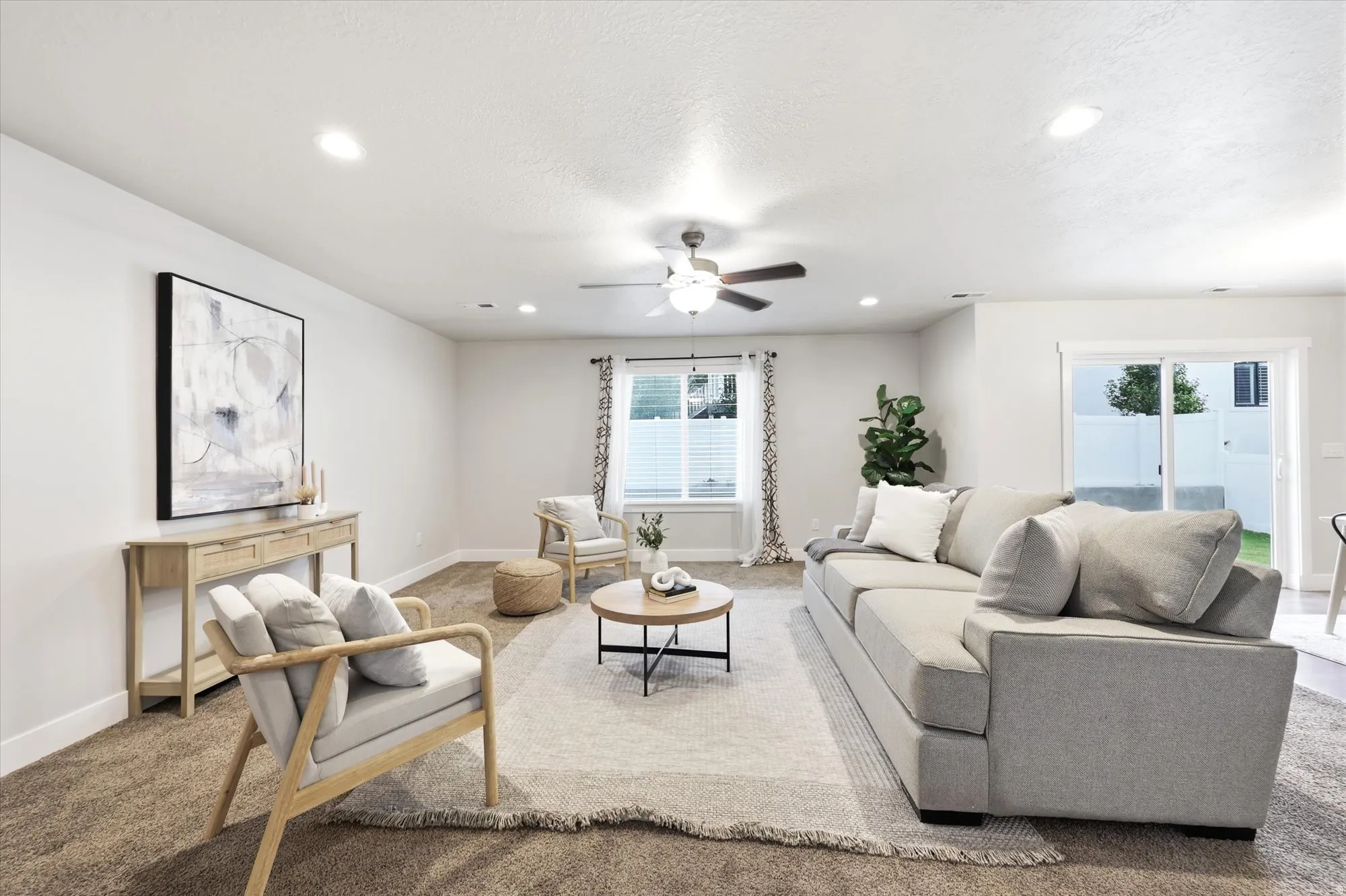 Spacious living area featuring neutral walls, recessed lighting, and a ceiling fan