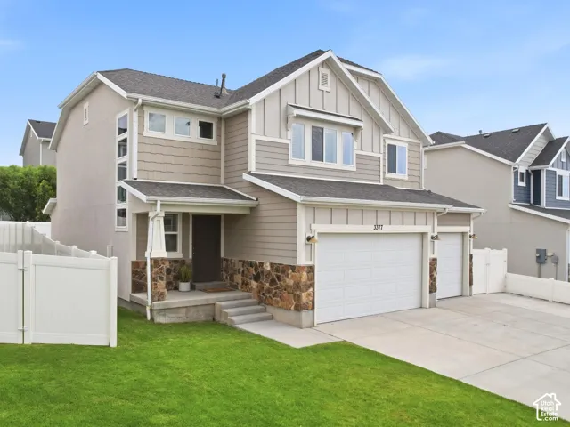 Contemporary two-story residence featuring a multi-textured facade with stone, horizontal siding, and vertical board and batten accents