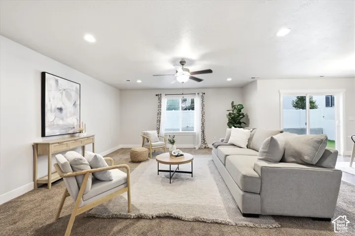 Spacious living area featuring neutral walls, recessed lighting, and a ceiling fan