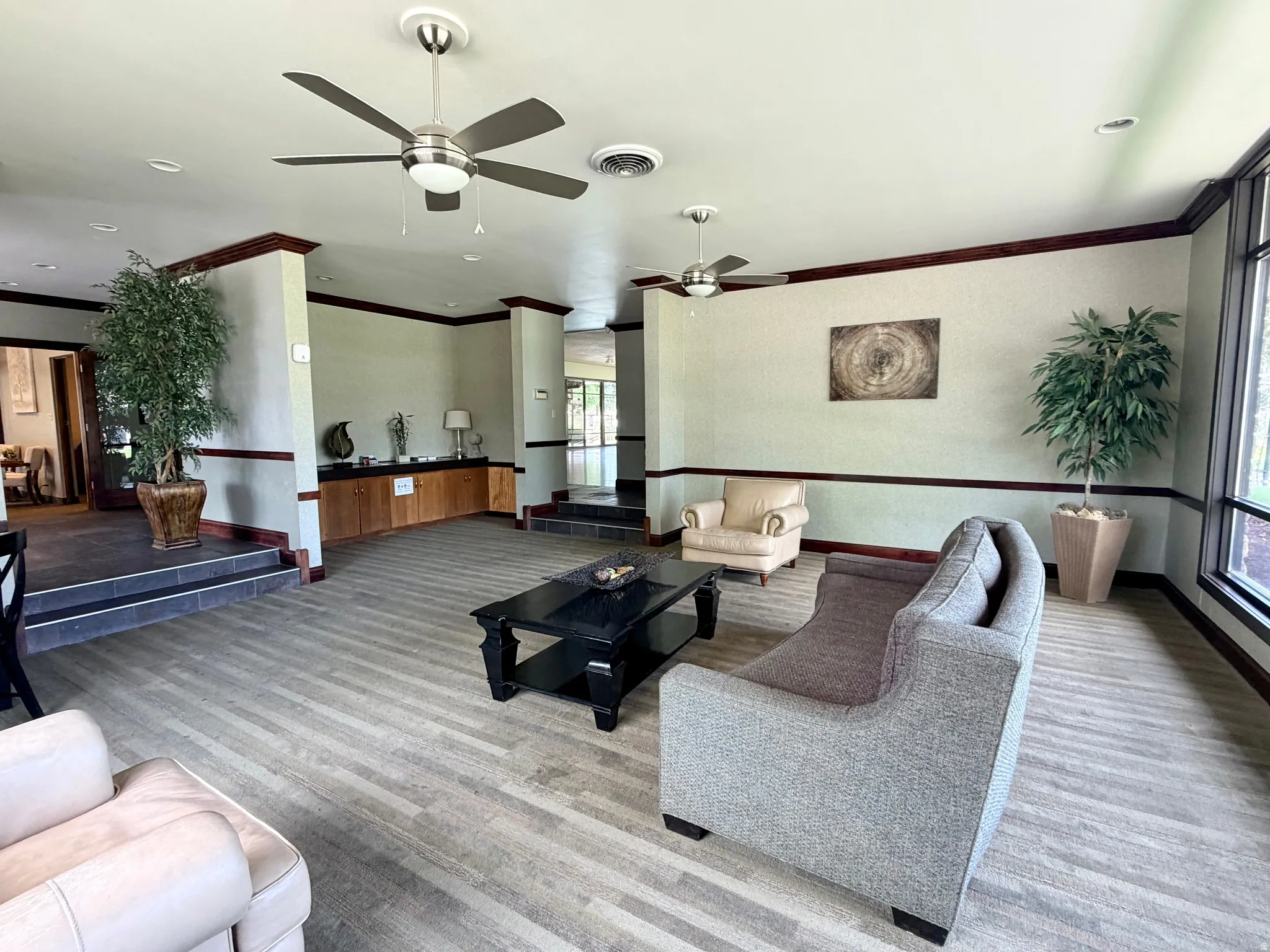 Spacious common area featuring plank-style flooring, built-in cabinetry, and large windows
