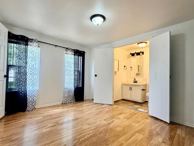 Spacious room featuring wood-finish flooring and two windows