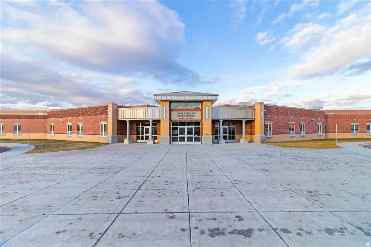 Brick exterior with a prominent main entrance featuring a metal awning and large glass doors