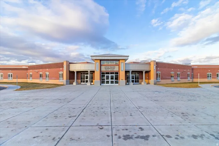 Brick exterior with a prominent main entrance featuring a metal awning and large glass doors