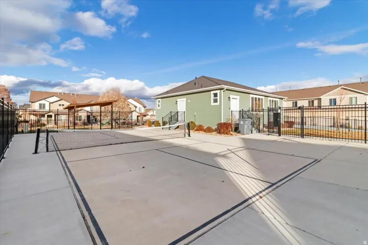 Outdoor sports court featuring a concrete surface and perimeter fencing