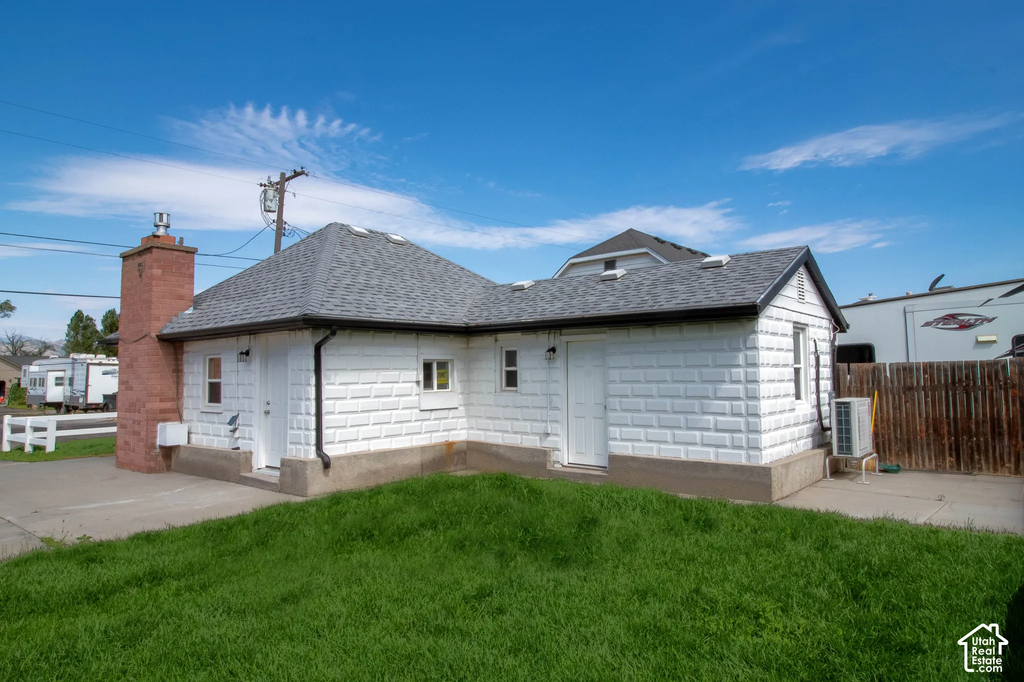 White textured exterior with a gray shingle roof and contrasting dark trim