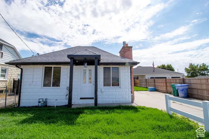 White exterior siding with a dark asphalt shingle roof and a covered entryway
