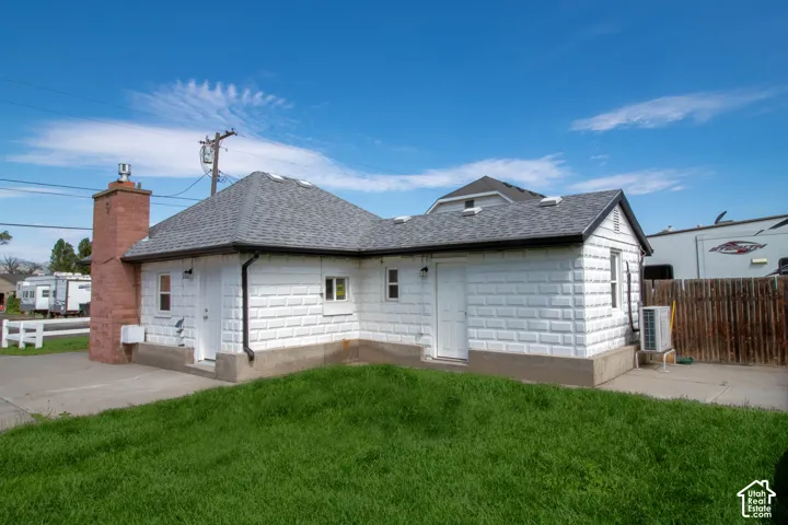 White textured exterior with a gray shingle roof and contrasting dark trim