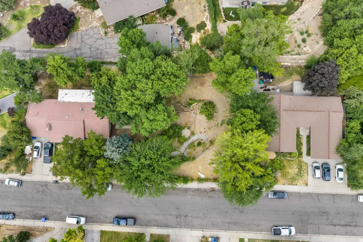 Aerial view showcasing two residential properties featuring mature landscaping and private driveways