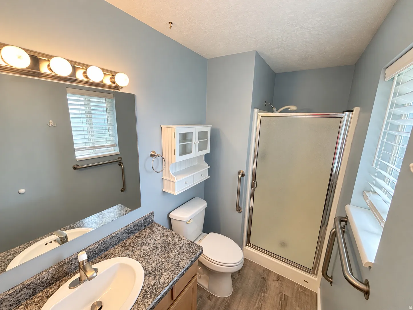 Bathroom featuring a vanity with an integrated sink, granite-style countertop, and chrome faucet