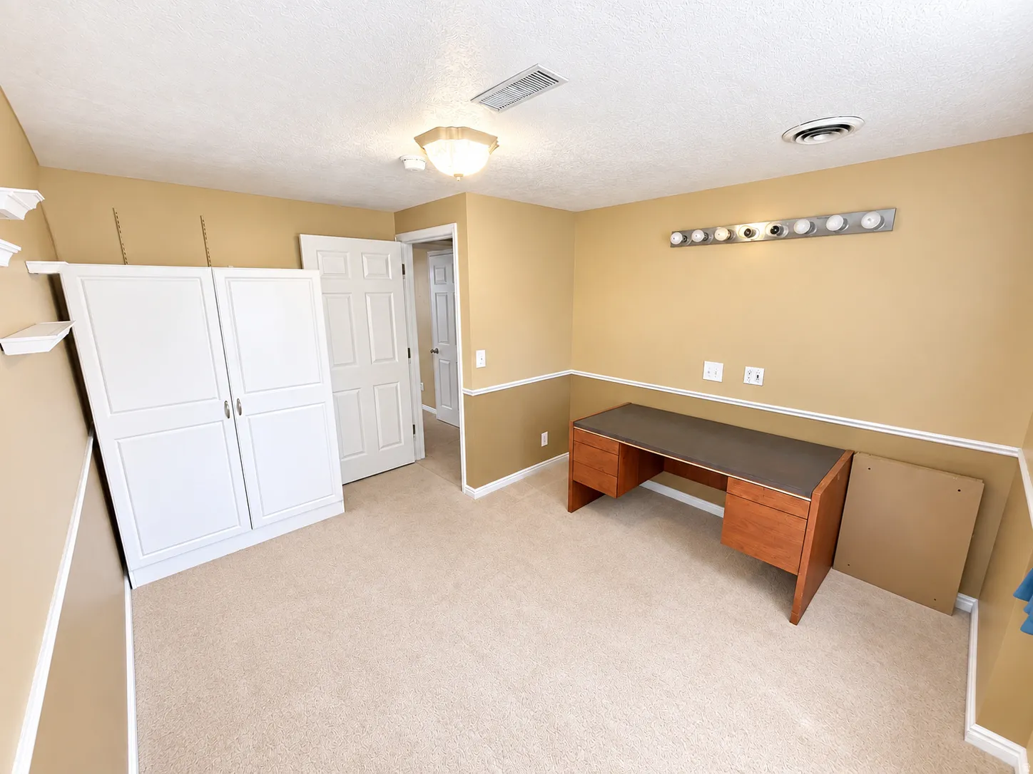 Carpeted room with crown molding, chair rail, and a semi-flush mount ceiling light