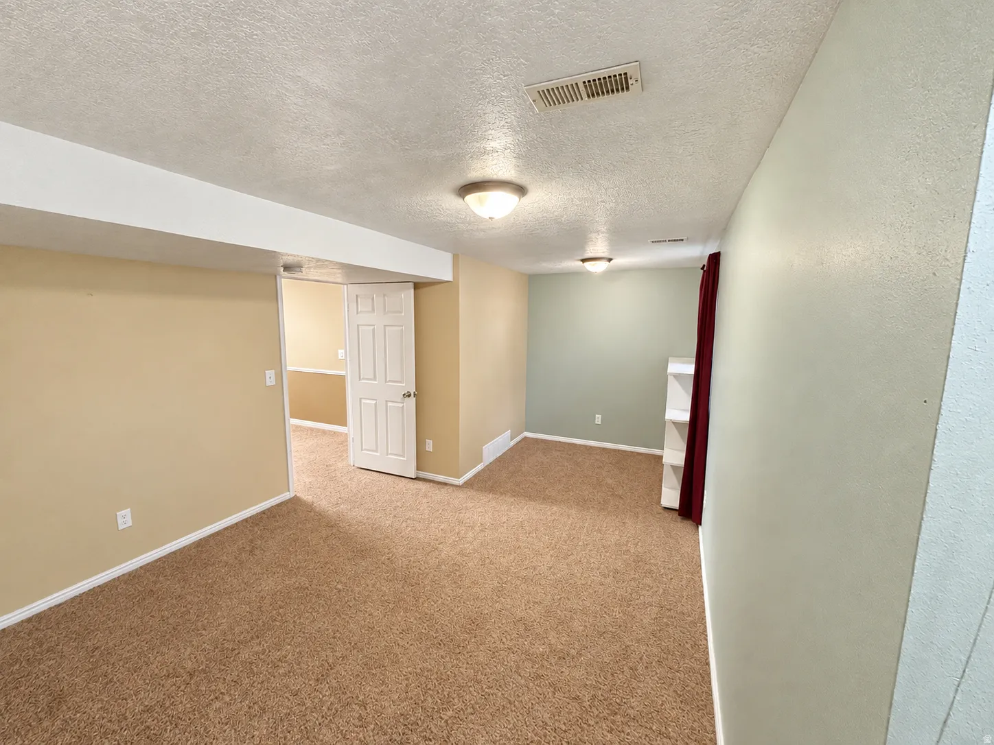 Carpeted flooring, recessed lighting, and a white built-in shelving unit
