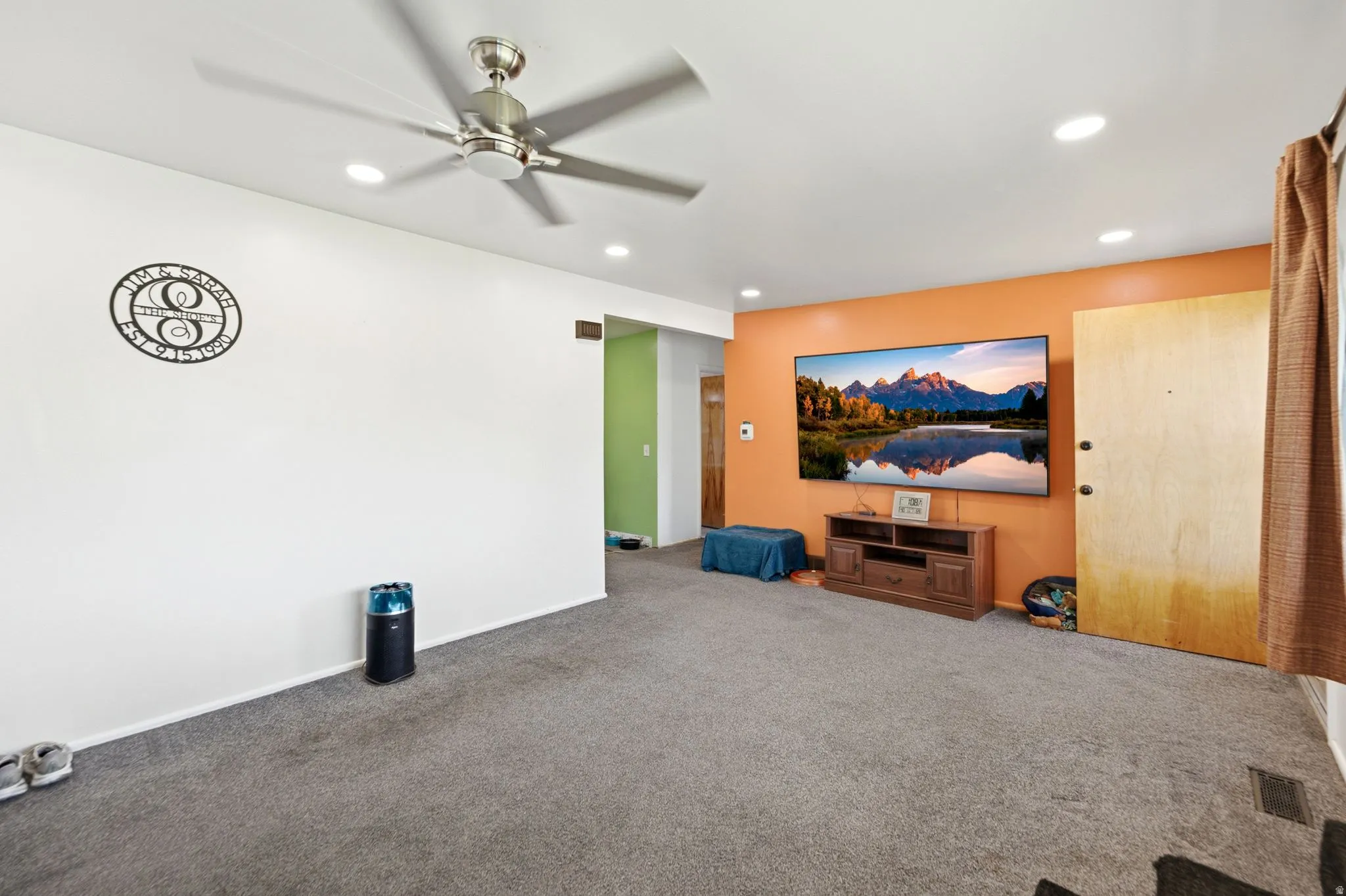 Spacious room featuring gray carpet, recessed ceiling lighting, and a modern ceiling fan