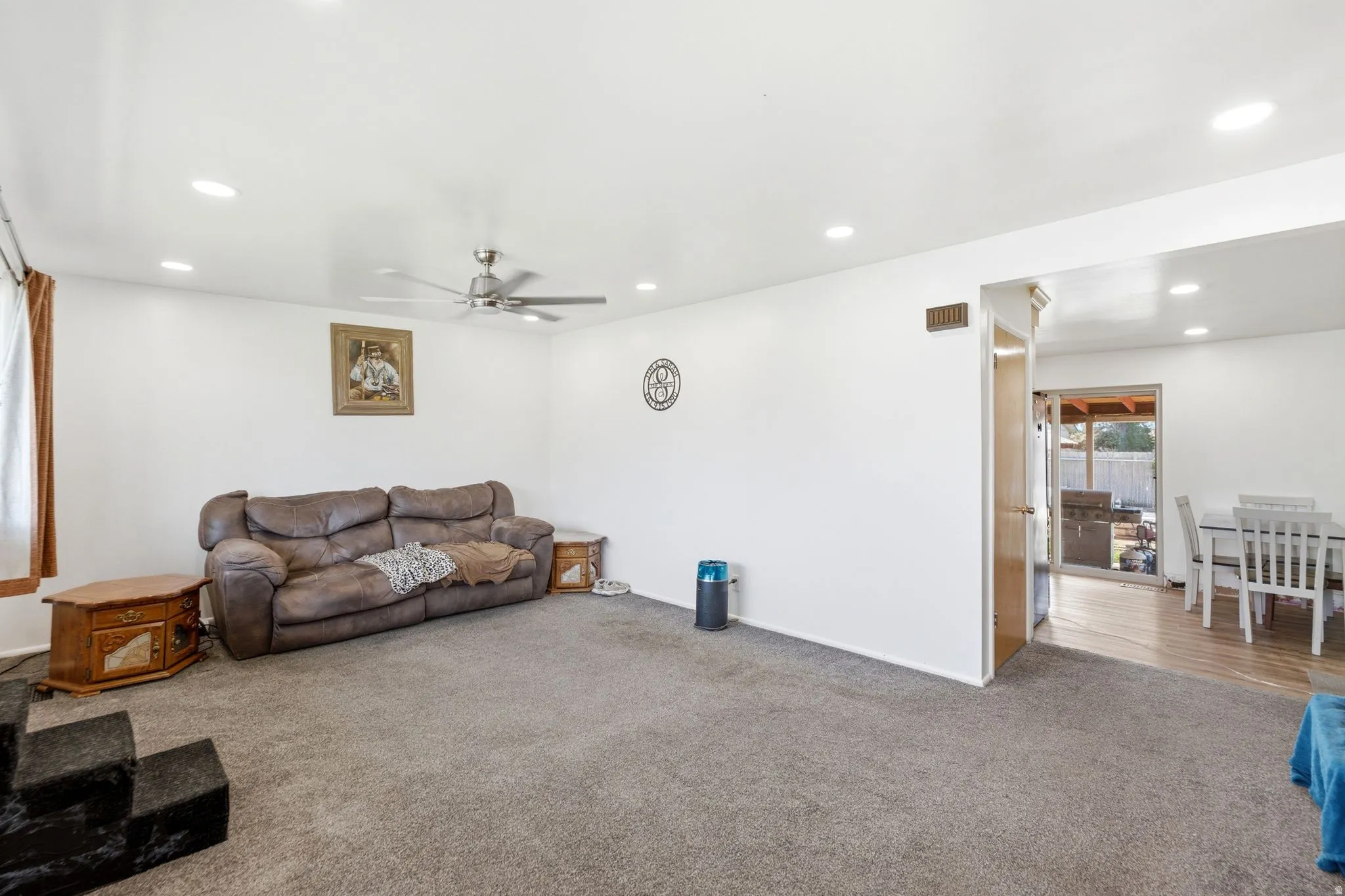 Spacious room featuring neutral carpeting, recessed lighting, and a ceiling fan