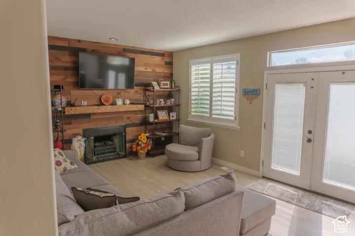 Living area with a wood-paneled accent wall, a built-in fireplace, and a wood mantel