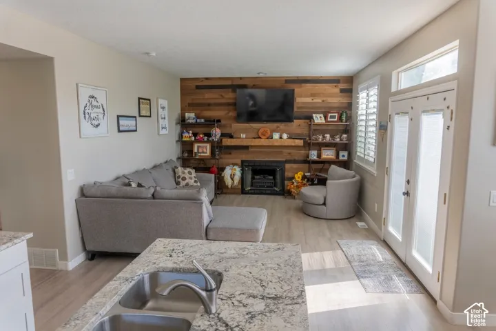 Living area featuring a floor-to-ceiling wood plank accent wall with a built-in electric fireplace and wood mantel