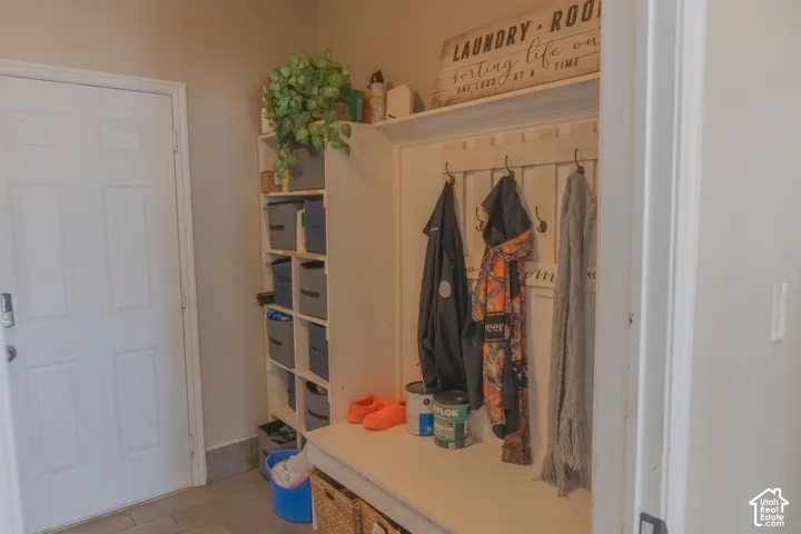 Mudroom entry featuring a built-in bench, wall-mounted coat hooks, and integrated shelving