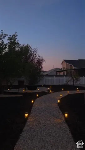 Gravel pathway with perimeter lighting, surrounded by landscaped dark ground cover