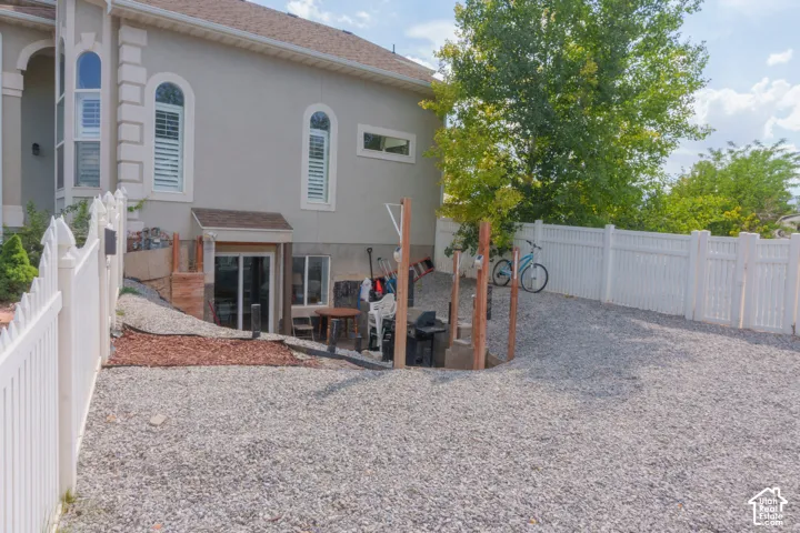 Lower level patio access featuring sliding glass doors and a gravel ground cover