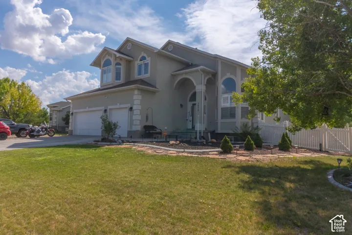 Stucco exterior with decorative trim, arched entry, multiple arched windows, and a two-car garage