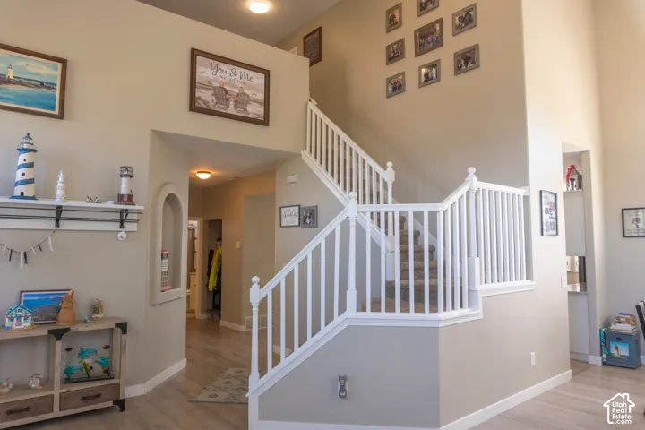 Multi-level interior featuring a white baluster staircase and wood-finish flooring