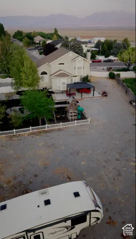 Two-story exterior with an attached bay window, covered patio, and gravel driveway