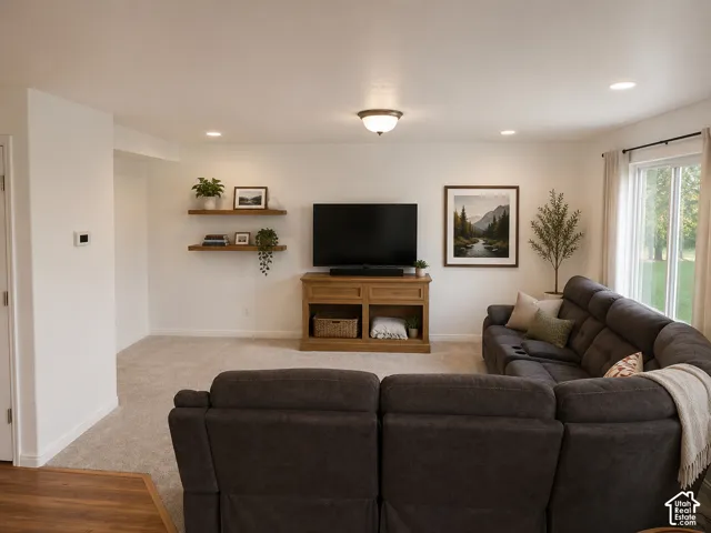 Spacious living area featuring light-colored carpet, recessed lighting, and a sliding glass door. Some decor digitally added.
