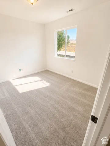 Room featuring light gray carpeting, crisp white walls, and a recessed window with white trim