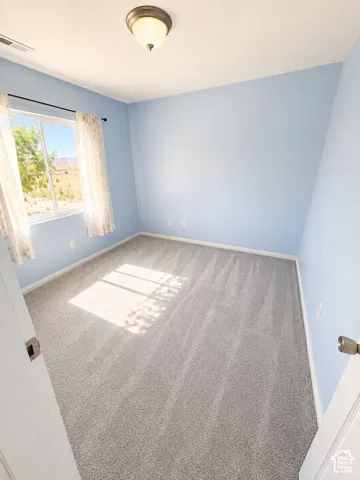 Bright room with light blue walls and gray carpeting